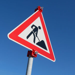 Mit Klemmschellen am Schaftrohr montiertes Baustellenschild