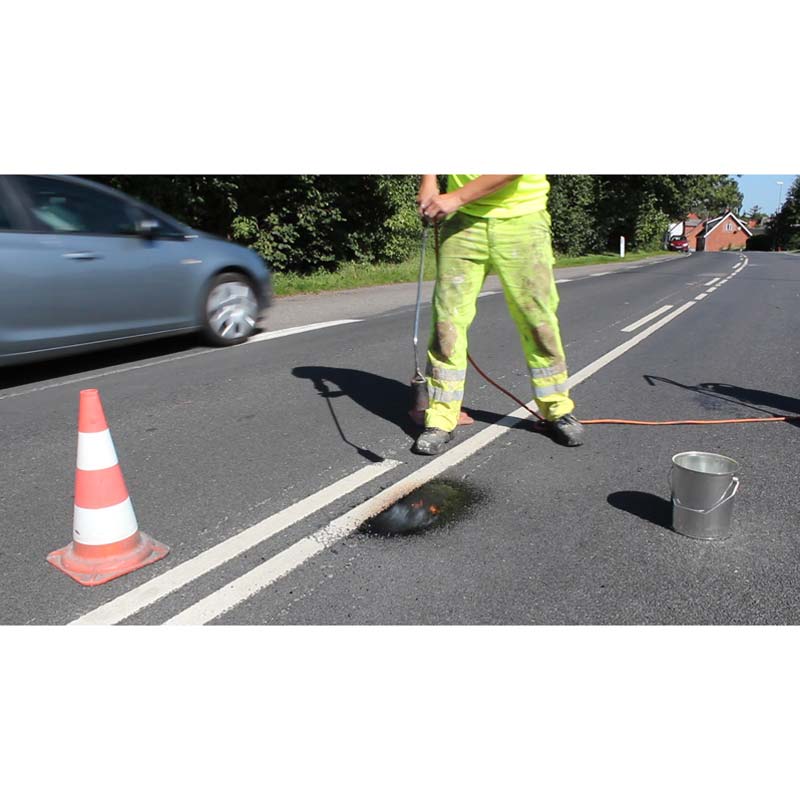 geschmolzenes Granulat verbindet sich mit dem Asphalt